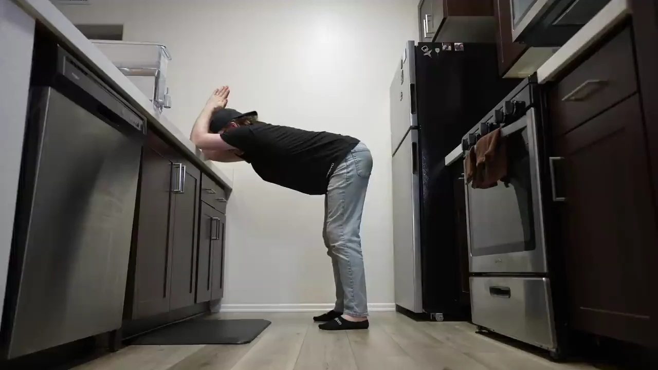 Hard standing lat stretch with hands on a wall and torso hinged forward
