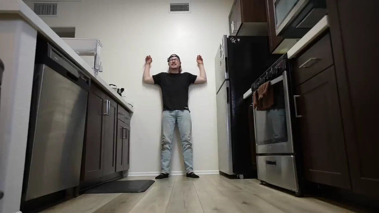 Full-body wall-angel position against the wall with elbows bent